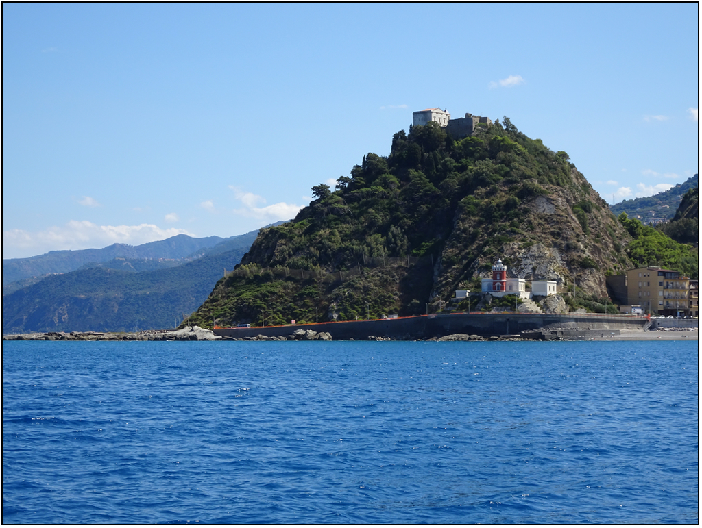 Pic rocheux surplombant la mer et surmonté d'un édifice religieux. Le phare, lui, est niché au bas du dit pic. 